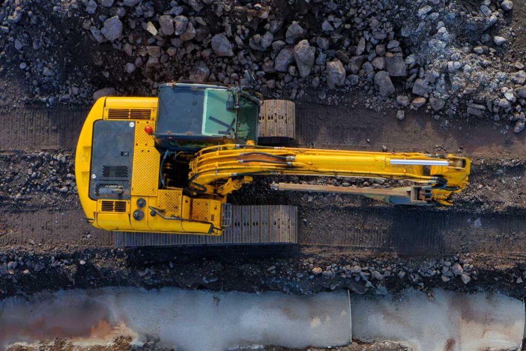 Aerial view of heavy construction equipment at a worksite, representing project execution, resource coordination, and operational efficiency in construction and infrastructure projects.