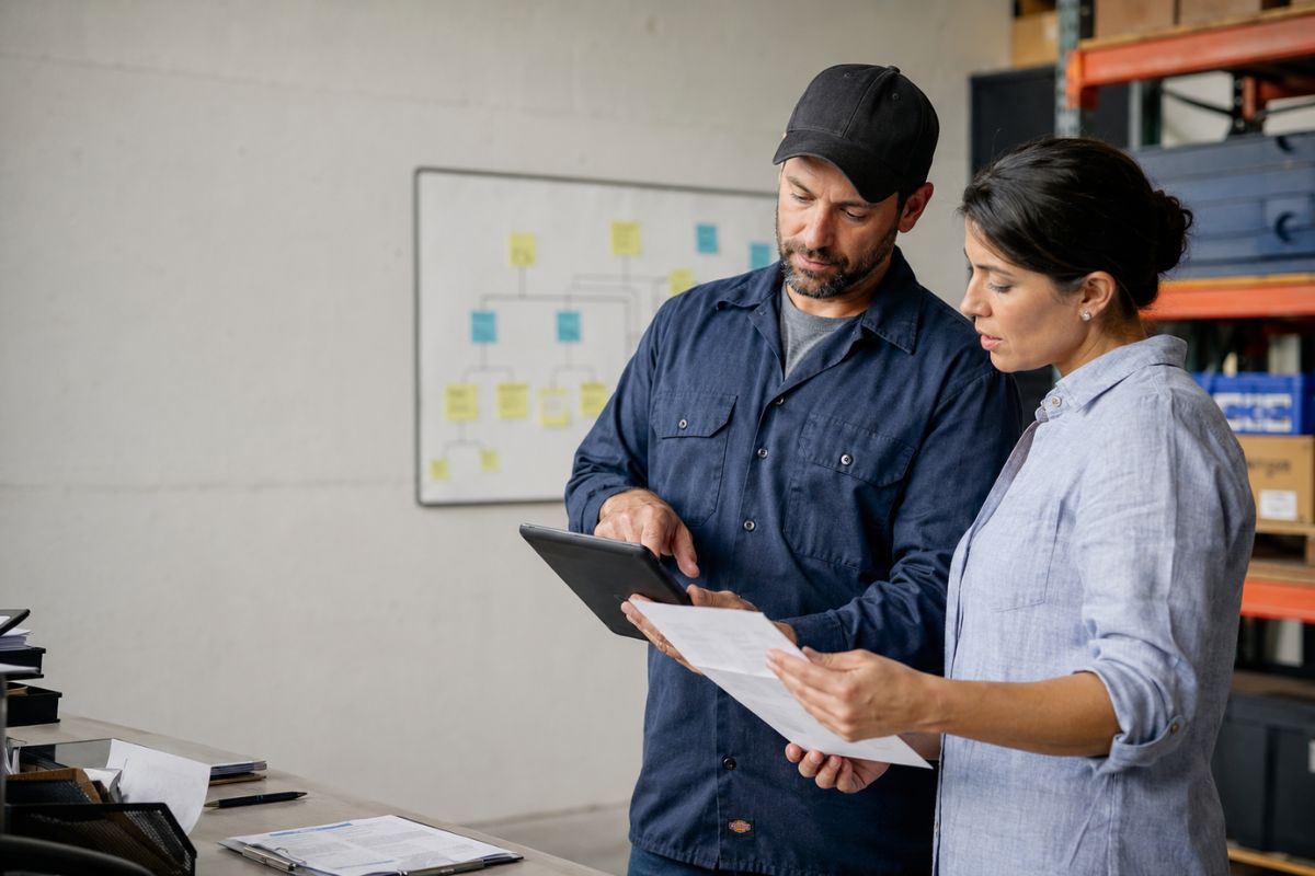 Field technician and operations manager reviewing a service workflow together